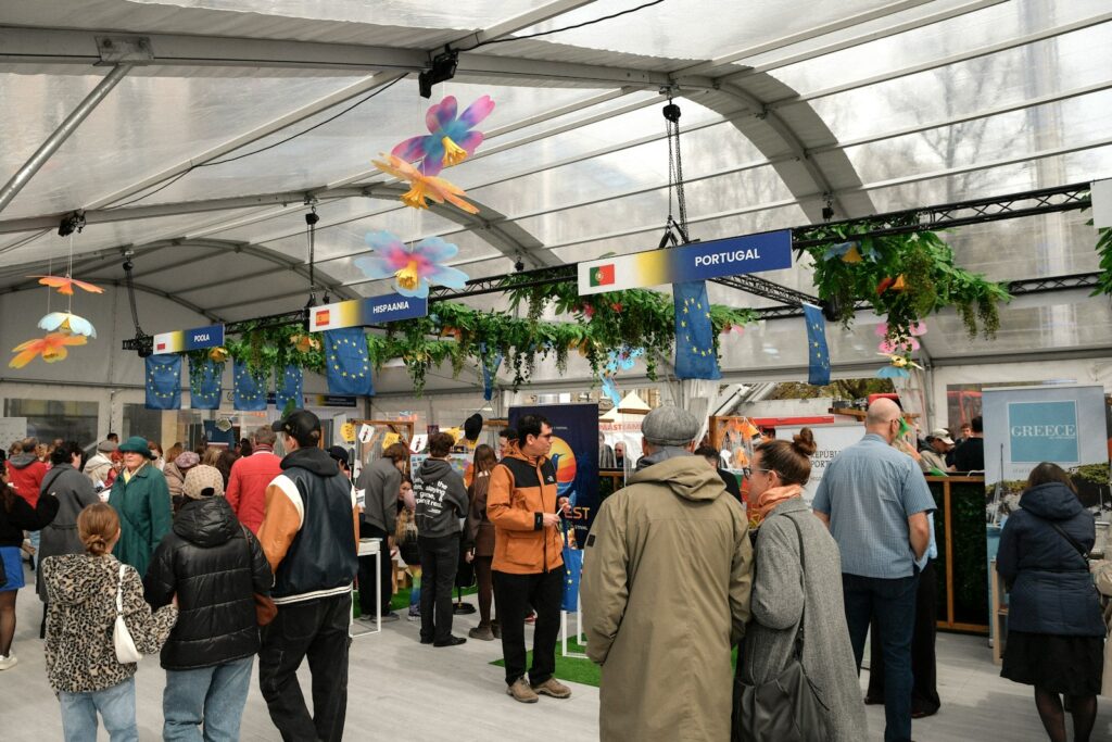 Crowd of visitors walking through an international food trade show with country pavilions