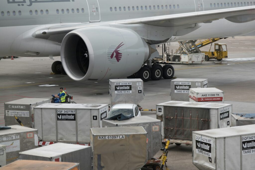 Air cargo containers being loaded onto an international airline for export
