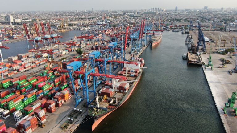 Aerial view of a busy shipping port with cranes and stacked cargo containers