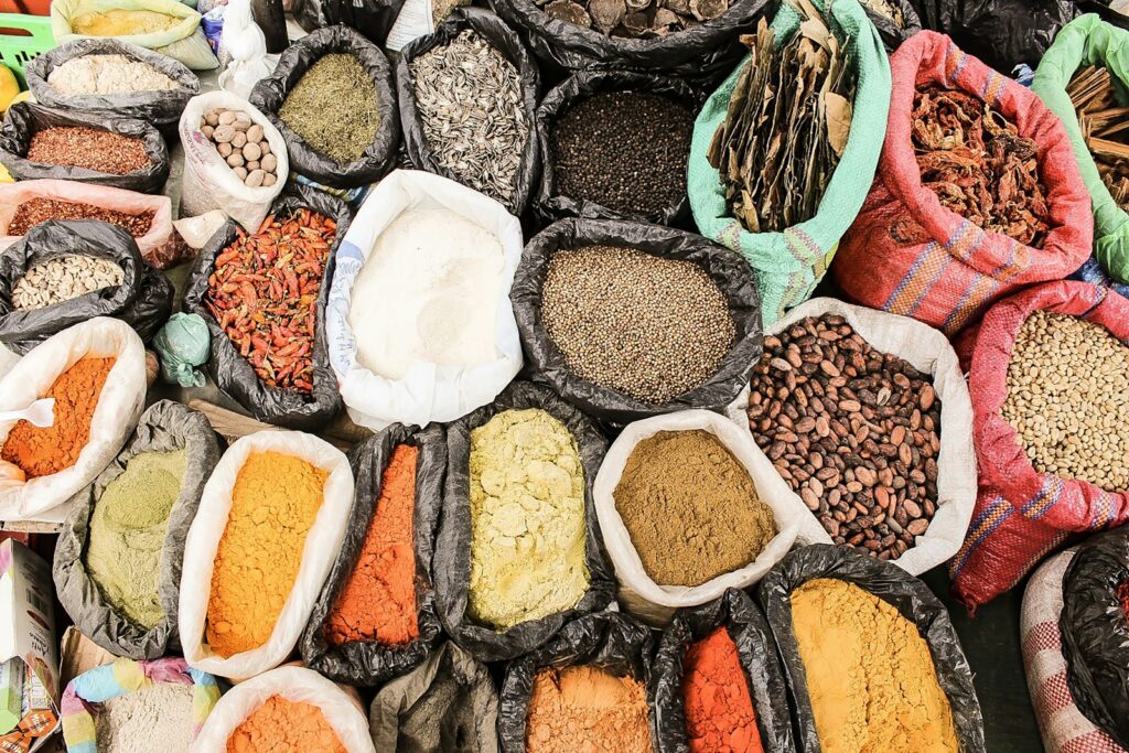 Mercado artesanal tradicional en Otavalo, Ecuador, con sacos de semillas y especias